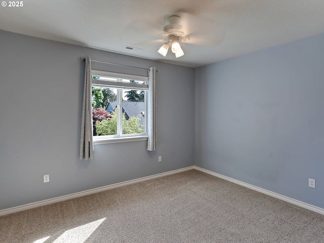 carpeted empty room with ceiling fan and baseboards