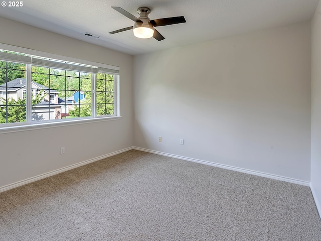 unfurnished room with carpet floors, a ceiling fan, and baseboards