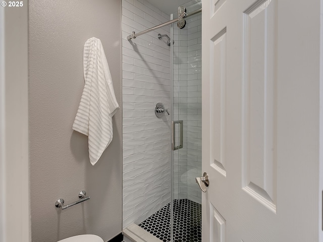 bathroom with a shower stall and toilet