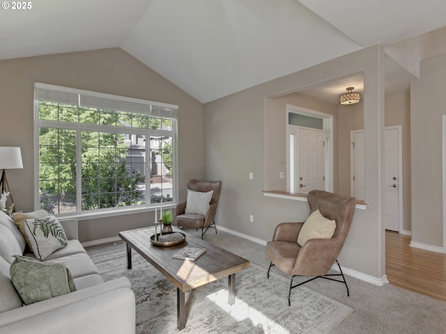 carpeted living room with vaulted ceiling and baseboards