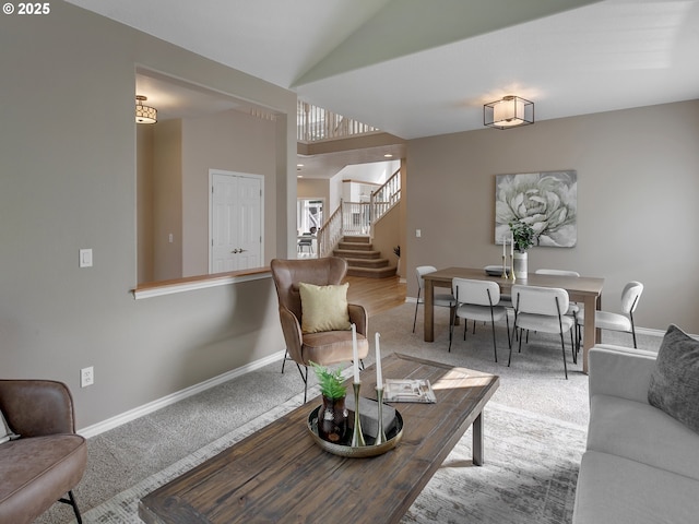 living area featuring stairs, carpet flooring, baseboards, and vaulted ceiling