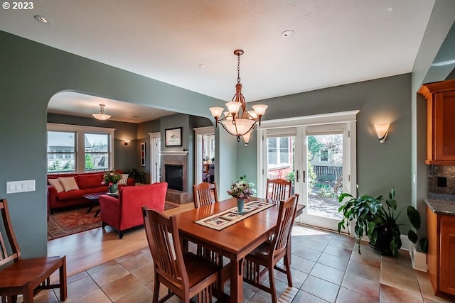 1603 Berkeley Ln, Monmouth, OR 97361 - dining room with arched walkways, a fireplace, light tile patterned floors, a chandelier, and recessed lighting