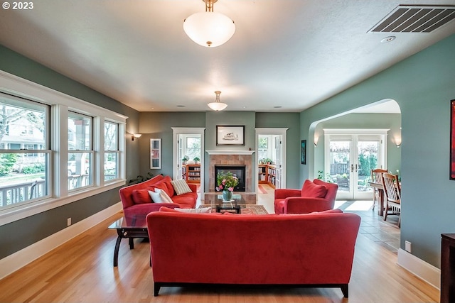 1603 Berkeley Ln, Monmouth, OR 97361 - living room with a tiled fireplace, baseboards, arched walkways, and light wood-style floors