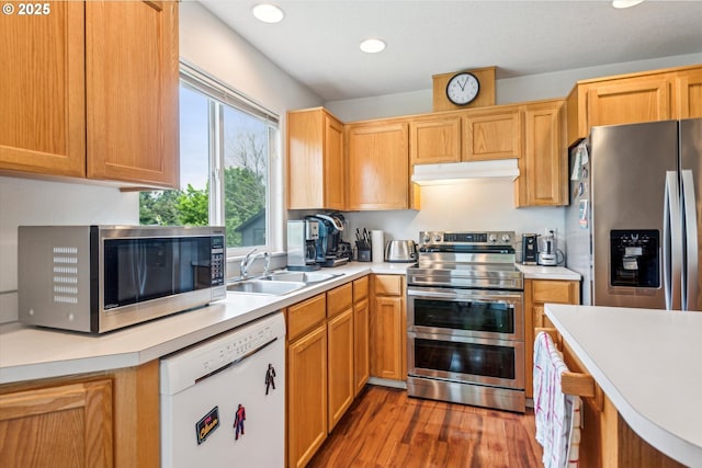 19030 SW Pike Ln, Beaverton, OR 97078 - kitchen with stainless steel appliances, a sink, under cabinet range hood, wood finished floors, and light countertops