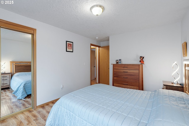 2176 SE 63rd Ave, Hillsboro, OR 97123 - bedroom with light wood-type flooring, a textured ceiling, and baseboards