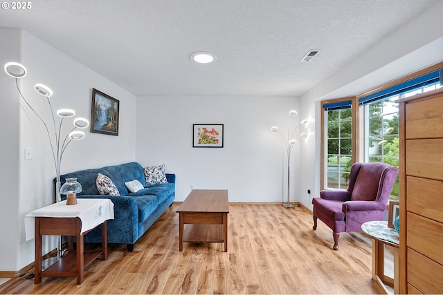 2176 SE 63rd Ave, Hillsboro, OR 97123 - living room featuring light wood finished floors, baseboards, and a textured ceiling