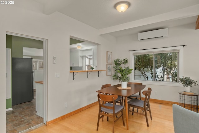 dining area with light hardwood / wood-style flooring and a wall mounted AC