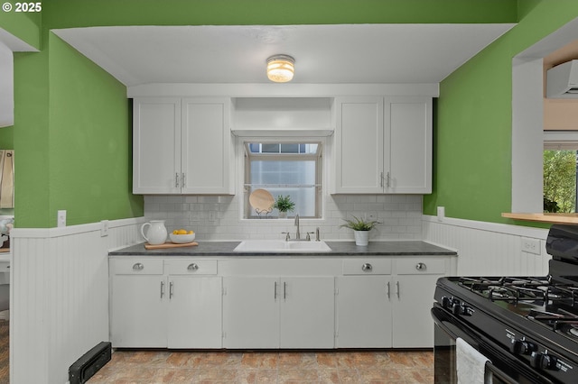 kitchen featuring white cabinetry, plenty of natural light, sink, and black gas range