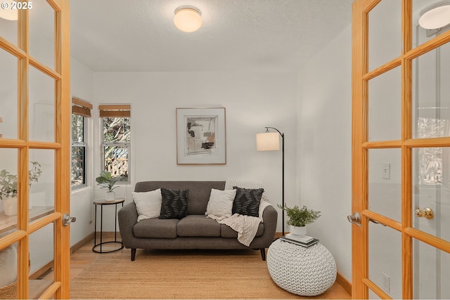 living room with a textured ceiling and light hardwood / wood-style floors