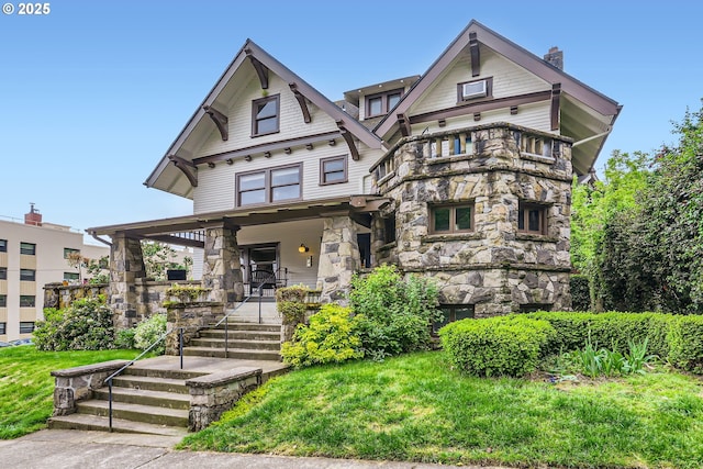 2566 NW Lovejoy St Unit 4, Portland, OR 97210 - victorian-style house featuring stone siding, a porch, a chimney, and a balcony