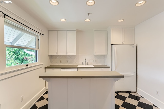 2566 NW Lovejoy St Unit 4, Portland, OR 97210 - kitchen featuring freestanding refrigerator, light floors, a sink, recessed lighting, and white cabinetry