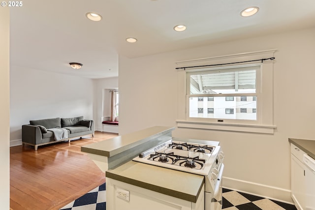 2566 NW Lovejoy St Unit 4, Portland, OR 97210 - kitchen with white range with gas stovetop, light floors, plenty of natural light, recessed lighting, and baseboards