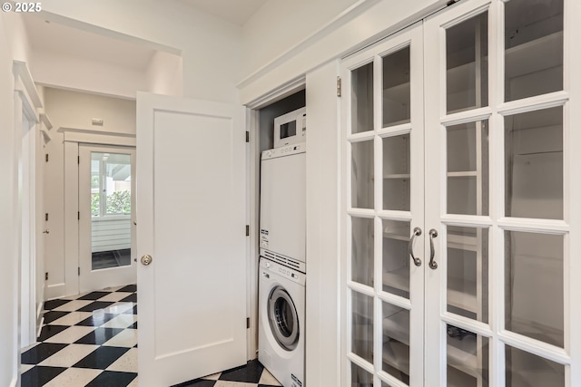 2566 NW Lovejoy St Unit 4, Portland, OR 97210 - laundry room with stacked washing machine and dryer, tile patterned floors, and french doors