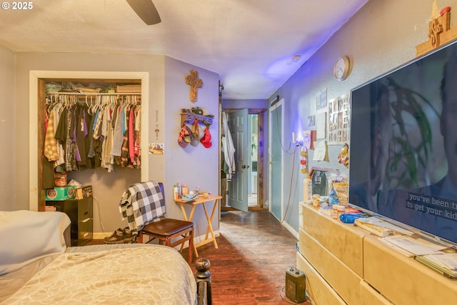 bedroom featuring wood finished floors, baseboards, a textured ceiling, and ceiling fan