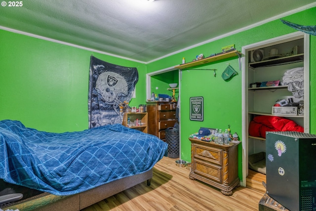 bedroom featuring wood finished floors and crown molding