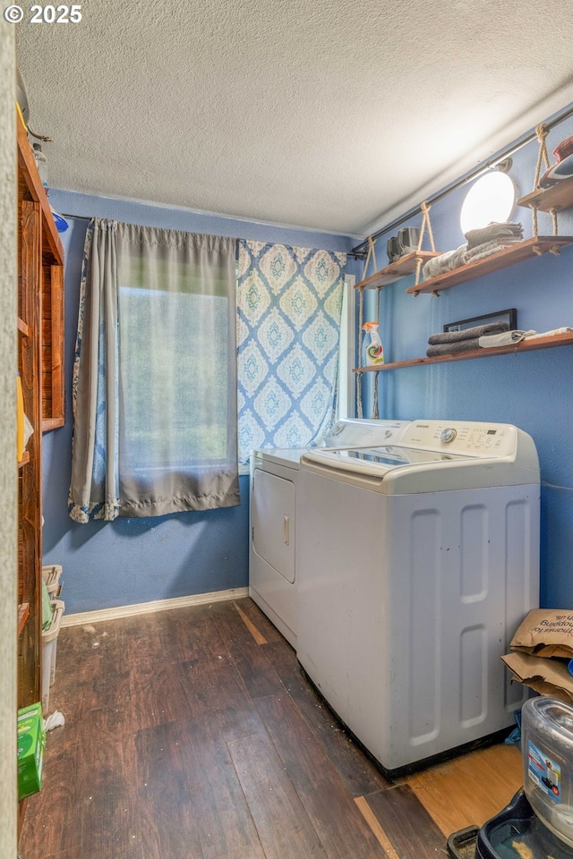 washroom with washing machine and dryer, hardwood / wood-style flooring, a textured ceiling, and baseboards