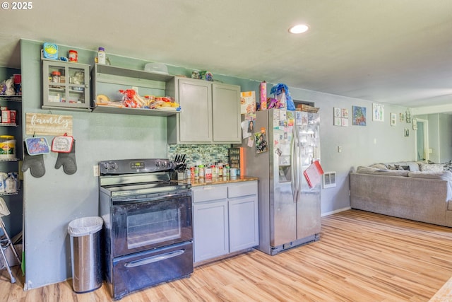 kitchen with black range with electric cooktop, stainless steel refrigerator with ice dispenser, light wood finished floors, open floor plan, and recessed lighting