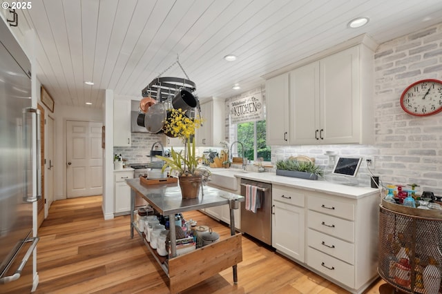15785 SW Bull Mountain Rd, Portland, OR 97224 - kitchen featuring appliances with stainless steel finishes, wooden ceiling, backsplash, light countertops, and light wood-style flooring