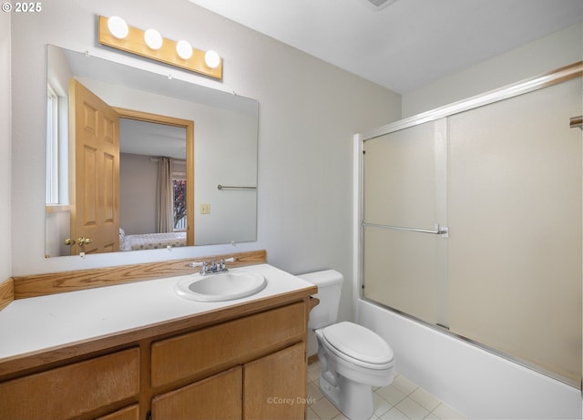 full bathroom featuring toilet, vanity, bath / shower combo with glass door, and tile patterned floors