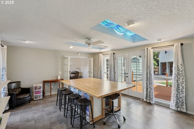 243 N 30th Ct, Cornelius, OR 97113 - dining area featuring french doors, a textured ceiling, a skylight, and ceiling fan