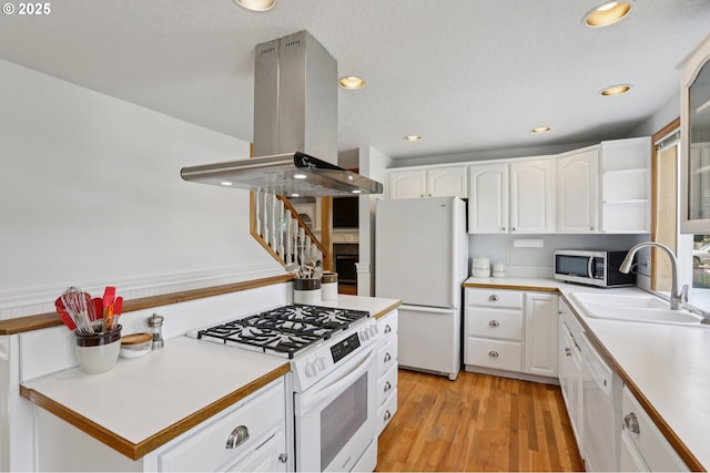 243 N 30th Ct, Cornelius, OR 97113 - kitchen featuring white appliances, island exhaust hood, white cabinetry, light countertops, and recessed lighting