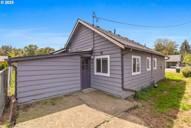 rear view of house featuring fence and a patio
