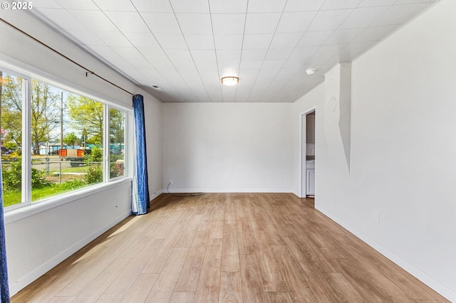 empty room featuring baseboards and light wood finished floors