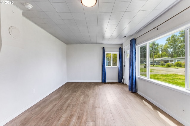 empty room with baseboards and light wood-style flooring
