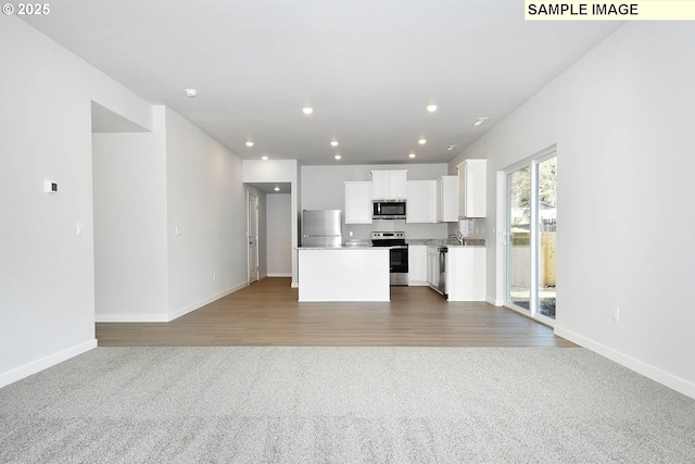 5318 NE 68th St, Vancouver, WA 98661 - unfurnished living room with baseboards, carpet floors, wood finished floors, and recessed lighting