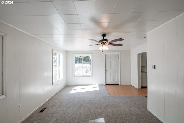 unfurnished room with carpet floors, ornamental molding, visible vents, and a ceiling fan