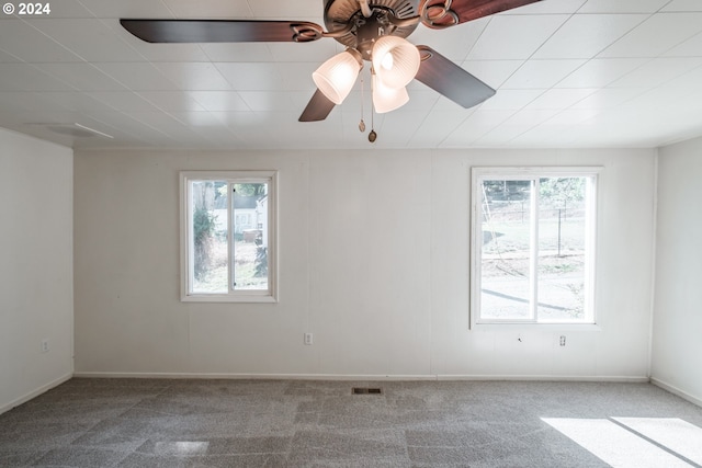 spare room featuring carpet, visible vents, ceiling fan, and baseboards