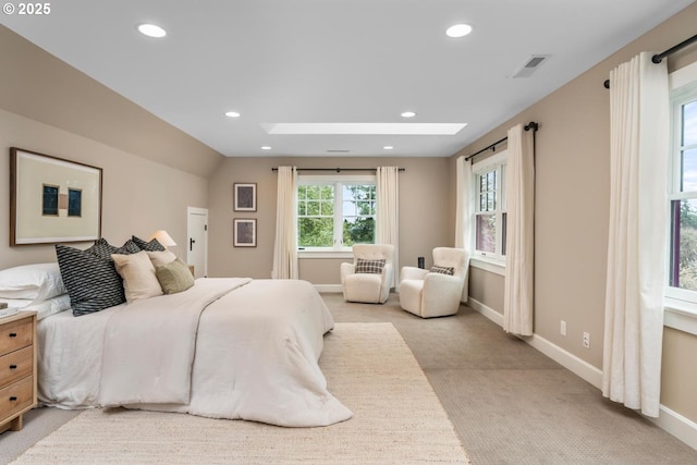 bedroom featuring visible vents, light carpet, recessed lighting, vaulted ceiling with skylight, and baseboards