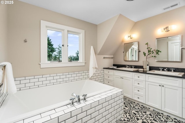 bathroom featuring double vanity, a bath, visible vents, and a sink