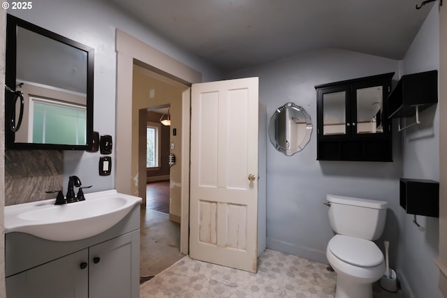 bathroom with toilet, vanity, and tile patterned flooring