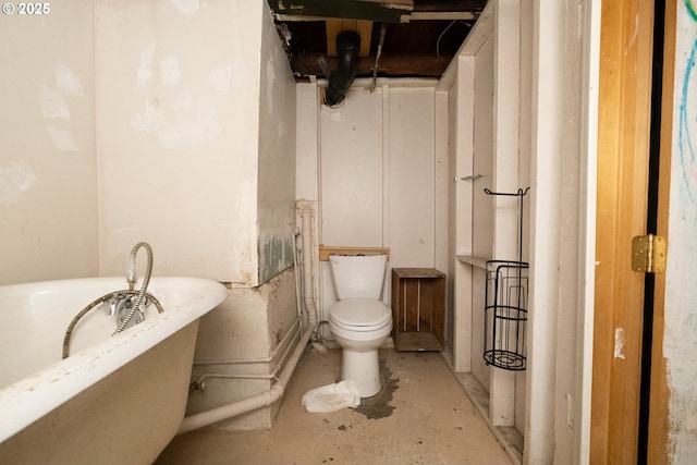 bathroom with a bathtub, toilet, and concrete flooring