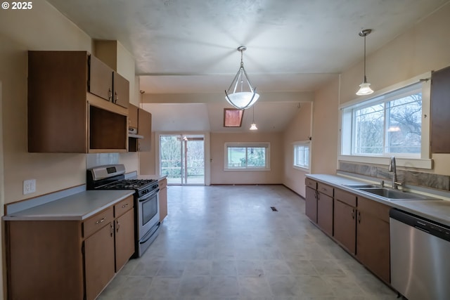 kitchen with lofted ceiling, extractor fan, pendant lighting, sink, and stainless steel appliances