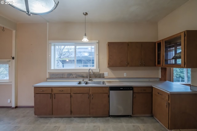 kitchen with decorative light fixtures, a wealth of natural light, dishwasher, and sink