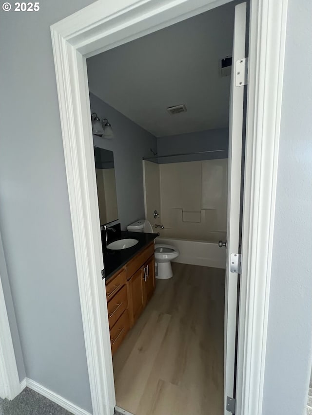 full bathroom with shower / bathtub combination, vanity, toilet, and wood-type flooring