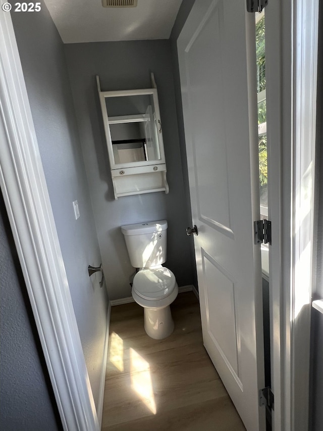 bathroom featuring wood-type flooring and toilet