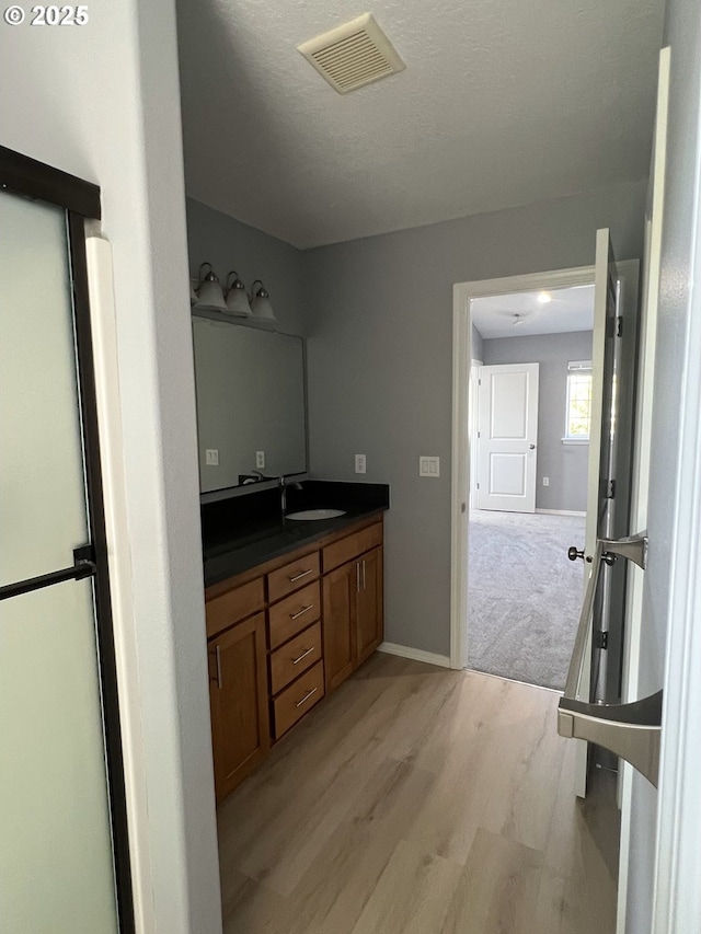 bathroom featuring vanity, hardwood / wood-style floors, and a textured ceiling