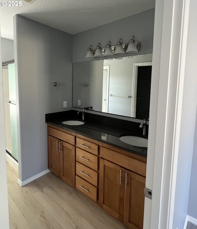 bathroom with vanity, wood-type flooring, and a textured ceiling