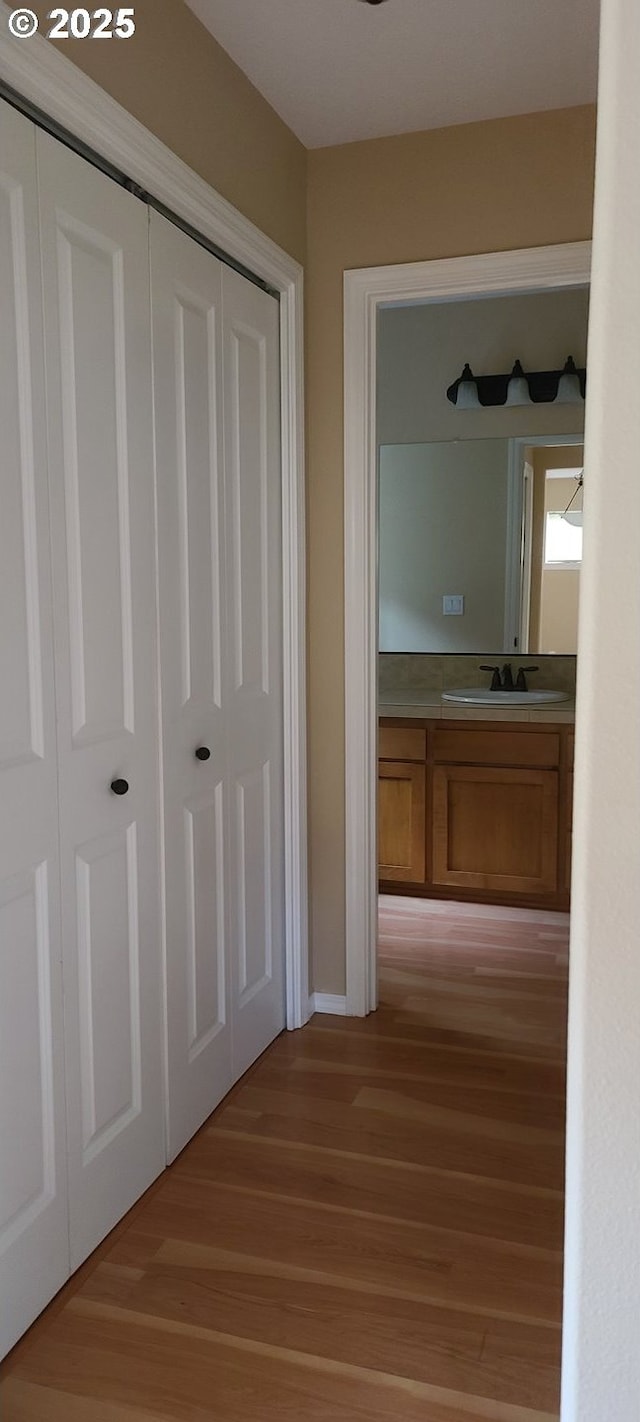 hallway with sink and light wood-type flooring