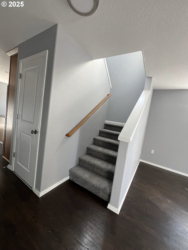 stairs with hardwood / wood-style flooring and a textured ceiling