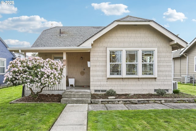 view of front of house with a front lawn and roof with shingles