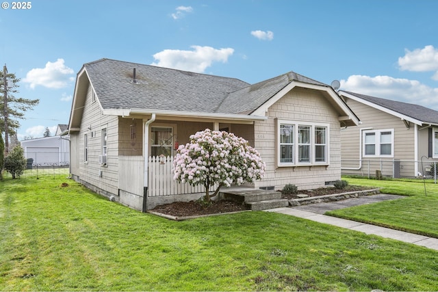 view of front of property featuring a front lawn, fence, and roof with shingles