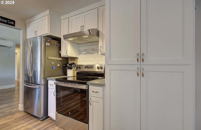 11204 NE 85th Cir, Vancouver, WA 98662 - kitchen featuring stainless steel appliances, under cabinet range hood, a wall mounted air conditioner, tasteful backsplash, and white cabinets