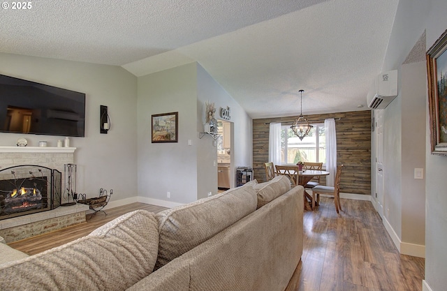 11204 NE 85th Cir, Vancouver, WA 98662 - living area featuring a wall mounted air conditioner, a textured ceiling, lofted ceiling, a brick fireplace, and wood finished floors