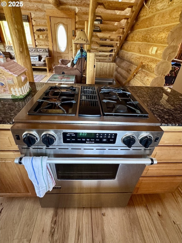 44552 Red Boy Rd, Granite, OR 97877 - kitchen with rustic walls, stainless steel range with gas cooktop, wood finished floors, and dark countertops