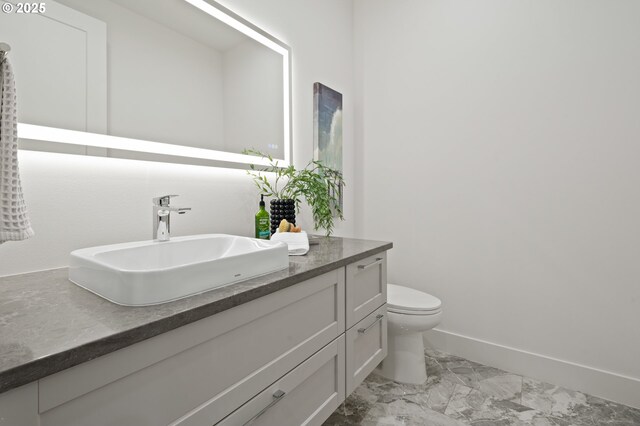 3884 Lake Grove Ave, Lake Oswego, OR 97035 - bathroom with marble look tile flooring, vanity, toilet, and baseboards