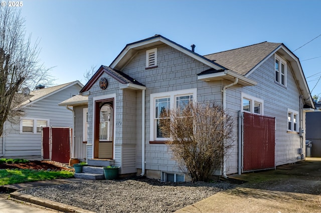 view of front of home with entry steps and a shingled roof